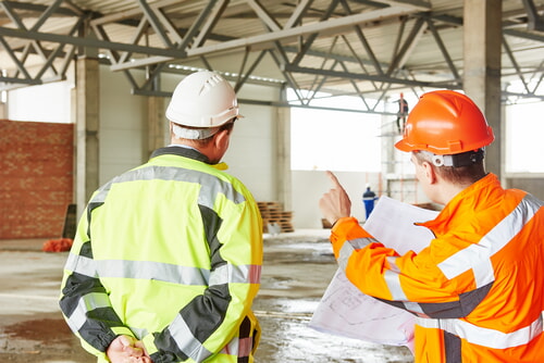 foreman and manager working at a construction site wearing high visibility jackets