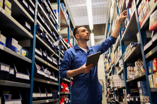 man working in auto parts warehouse picking stock for a customer