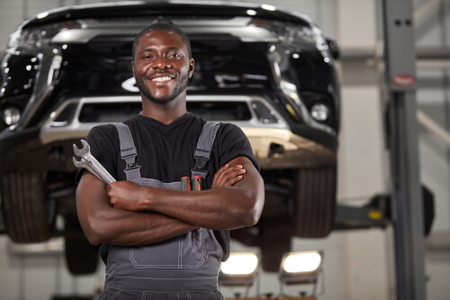 mechanic working in his garage workshop fixing an automobile car