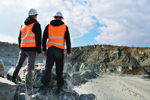 men wearing PPE working in a rock quarry