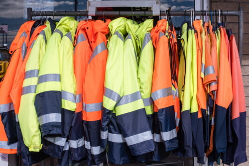 rack full of high visibility winter jackets in orange and greem