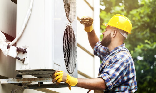 HVAC worker installing new air conditioning unit wearing the proper PPE